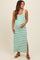 woman wearing a green and white striped maternity maxi dress, showing her baby bump and standing with one hand on her belly