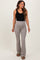 woman wearing a black tank top and taupe maternity flared leggings with a supportive waistband