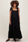 woman wearing a black tiered maternity maxi dress with bow tie straps and a visible baby bump