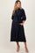 woman wearing a navy blue maternity shirt dress with a tie waist and pockets, showcasing her baby bump
