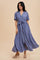 woman wearing a floral print blue maxi dress with short sleeves and a tie-waist detail
