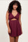 woman wearing a burgundy ribbed mini dress with ruffle details and a cutout at the waist