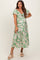 woman wearing a green floral maternity dress with puff sleeves and a tie-front detail, showcasing her baby bump