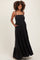 woman wearing a black square neck maternity maxi dress with pockets and a baby bump visible