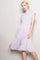 woman wearing a lavender floral print midi dress with ruffled sleeves and a tiered skirt