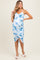 woman wearing a blue and white floral print maternity dress with ruching and a side slit, showing her baby bump