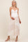 woman wearing a light pink and white tiered maternity dress with lace detailing and a baby bump visible
