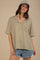 woman wearing an olive green and white striped oversized v-neck t-shirt with a front pocket and denim shorts