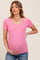 woman wearing a pink short sleeve maternity top and cradling her baby bump