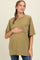 woman wearing an olive green oversized maternity tee with a lace pocket and gently holding her baby bump