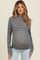 woman wearing a black and white striped maternity top and showing her baby bump