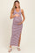 woman wearing a striped maternity maxi dress with side slit and holding her baby bump