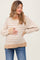 woman wearing a striped beige and cream maternity sweater and holding her baby bump