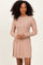 woman wearing a blush pink ribbed long sleeve dress with a flared hem and fitted silhouette