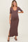 woman wearing a brown ribbed maternity maxi dress with short sleeves and side slits, showcasing her baby bump