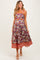 woman wearing a floral burgundy maternity dress with orange trim and an elastic waistband