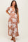 woman wearing a brown floral print maternity dress with puff sleeves and a v-neck, showcasing her baby bump