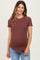 woman wearing a rust ribbed maternity t-shirt and showing her baby bump with light blue jeans