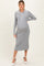 woman wearing a gray ribbed maternity dress with a collared neckline and buttons, showcasing her baby bump