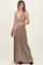 woman wearing a metallic gold halter maternity gown with a deep v-neck and a visible baby bump