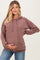 woman wearing a mauve ribbed maternity hoodie and holding her baby bump