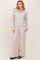 woman wearing a light beige zip-up hoodie and matching wide-leg pants in a ribbed fabric