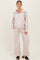 woman wearing a light beige maternity zip-up sweatshirt with wide-leg pants, styled for comfort during pregnancy