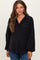 woman wearing a black oversized maternity top with a collar and pocket, showing off her baby bump