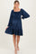 woman wearing a navy blue maternity dress with smocked bodice and flared skirt, showing off her baby bump