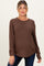 woman wearing a brown maternity sweater with a textured finish and a relaxed fit, showing her baby bump