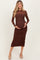 woman wearing a brown long sleeve maternity dress with ruching and holding her baby bump