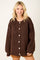 woman wearing a brown oversized button-up sweater with ribbed texture and drop shoulders