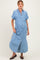 woman wearing a light blue denim maxi dress and showing her baby bump