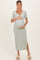 woman wearing a striped maternity dress with short sleeves and a side slit, gently cradling her baby bump
