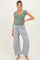 woman wearing a green ribbed maternity top and gray wide-leg sweatpants, showcasing a baby bump