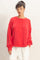 woman wearing a bright red long sleeve oversized sweatshirt with dropped shoulders and a relaxed fit