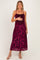 woman wearing a burgundy floral lace maternity dress with adjustable spaghetti straps and a baby bump visible