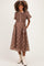 woman wearing a brown plaid maternity dress with short puff sleeves and pockets
