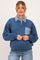 woman wearing a blue maternity sweatshirt with a checkered collar and pocket, holding her baby bump