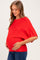 woman wearing a bright red short sleeve maternity top and holding her baby bump