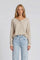 woman wearing a light beige long sleeve henley top with buttons, paired with light wash high-waisted jeans