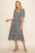 woman wearing a grey floral midi dress with short flutter sleeves and a flowing skirt