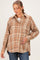 woman wearing a brown plaid maternity button-up shirt and gently resting her hand on her baby bump