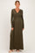 woman wearing an olive green long sleeve maternity dress with a v-neck and empire waist, showcasing her baby bump