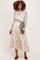 woman wearing a floral maternity dress with long sleeves and a green tie belt, showcasing her baby bump
