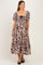 woman wearing a brown floral maternity dress with puff sleeves and a square neckline, standing with a relaxed pose