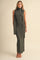 woman wearing an olive green sleeveless turtleneck maxi dress with a matching scarf detail