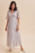woman wearing a light purple floral maxi dress with short flutter sleeves and a flowy silhouette