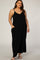 woman wearing a plus size black sleeveless maxi dress with pockets and white strappy sandals
