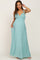 woman wearing a light teal maternity maxi dress with adjustable straps and pockets, showing off her baby bump